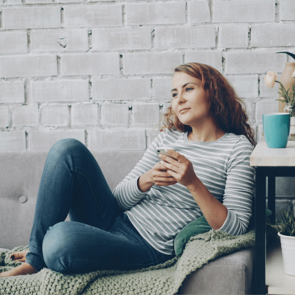Woman holding phone waiting on results from a pregnancy test.